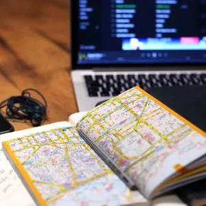Titelbild Artikel, zeigt aufgeschlagenes Notizbuch, im Hintergrund ein aufgeklapptes Notebook